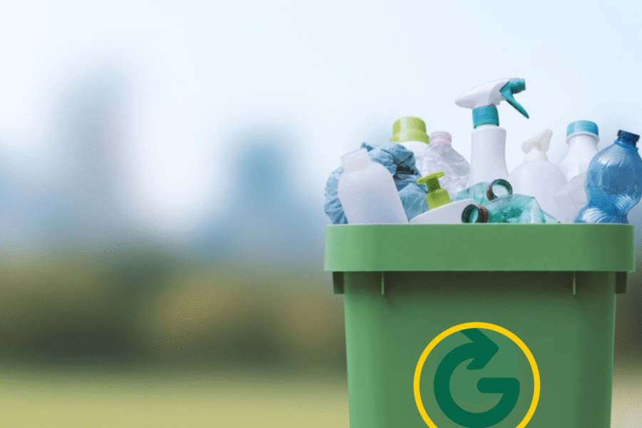 Green bin with the Greyhound Recycling logo filled with plastic recycling.