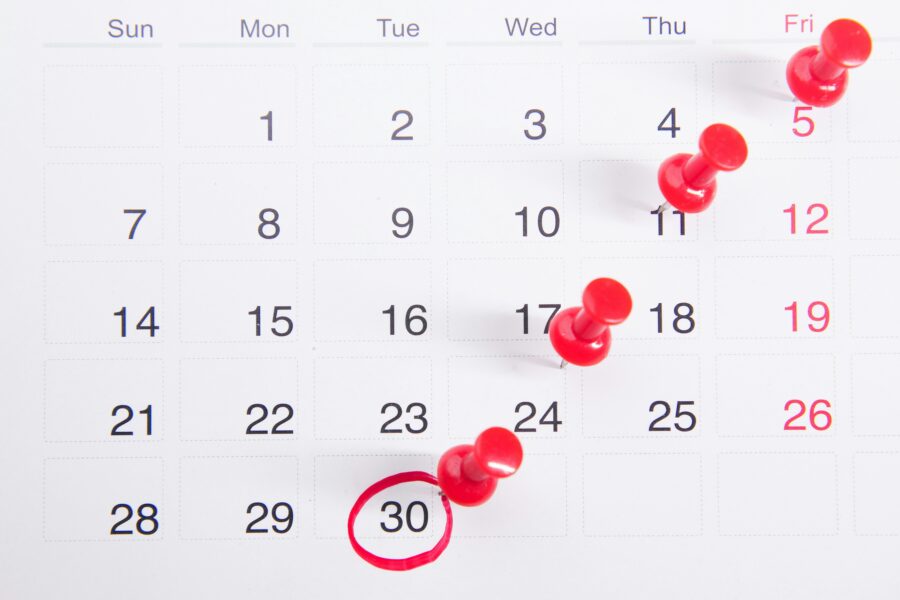 Calendar with dates marked in read with pins.